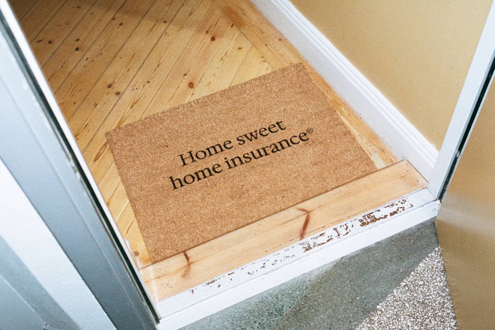 Dörrmatta i hallen med texten "Home sweet home insurance"